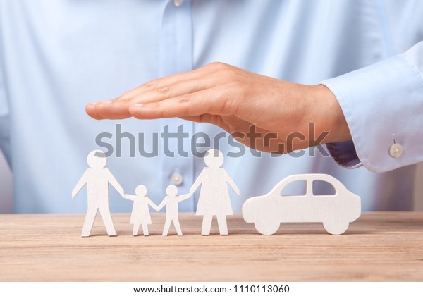 Family and car\
insurance. Man in  shirt covers his family with his father, mother,\
son and daughter and \
car.