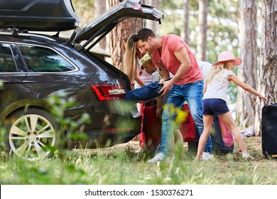 Family at the car loading from the trunk with luggage before traveling