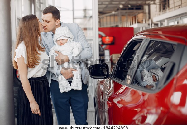 Family in a car salon. Woman buying the car.\
Little boy with a\
parents