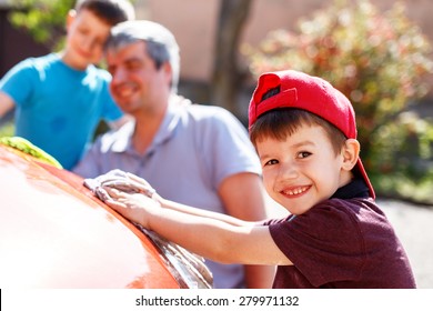 Family Car Wash, Little Boy Cleaning Spotlight, Father And Brother In Background