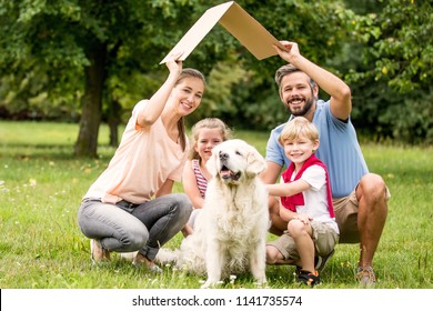 Family With Cardboard Roof As Building Construction Target Concept