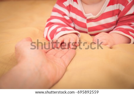 family care and support-mother holding hand of little baby