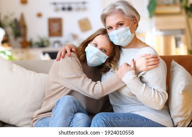 Family Care:  Young Woman Wearing A Medical Mask Visits An Elderly Mother During The Covid 19 Coronavirus Pandemic