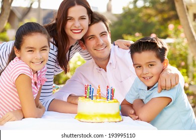 Family Celebrating Birthday Outdoors With Cake