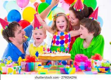 Family Celebrating Kids Birthday. Parents And Children Celebrate Together. Child Party With Balloon Decoration, Cake, Candles And Present Boxes. Celebration For Baby Boy, Toddler Girl And School Kid