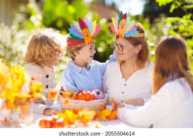 Family Celebrating Thanksgiving. Kids Autumn Arts And Crafts. Little Boy With Pumpkin And Turkey Hat At Decorated Table. Happy Celebration On Sunny Fall Day. Child Decorating Home.