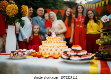 Family Celebration Birthday Baby Outside In Backyard.Big Garden Party. Selective Focus On The Cake With A Candle 5 Years Old, Blurred People Big Family On The Background Ukraine, Kiev July 20, 2017.