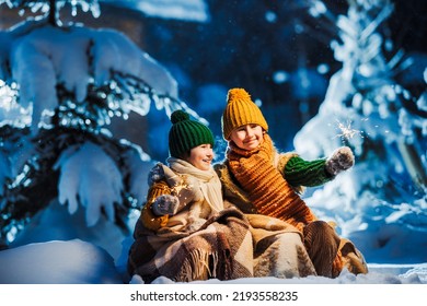 Family celebration of Merry Christmas or Happy New Year. Two children play with Bengal lights on fairy-tale night. Snowy Christmas tree on background. - Powered by Shutterstock