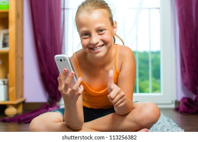 Family - child with cell or smartphone at home in the living room