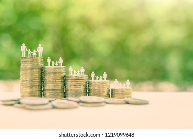 Family Or Child Trust Fund / Fundraising Concept : Family Members On Stacks Of Coins On A Table, Depicts Grantor Establishes A Trust Fund To Provide Financial Security To An Individual E.g Grandchild