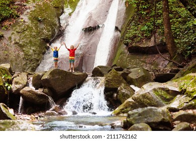 Family with child at waterfall. Travel with kids. Little boy hiking and trekking at jungle river. Summer vacation on exotic island. Active hike with young children. Adventure fun.