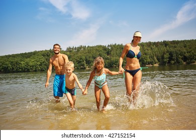 Family And Children Bathing In The Lake And Having Fun In Summer