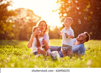 Family With Children Blow Soap Bubbles Outdoor