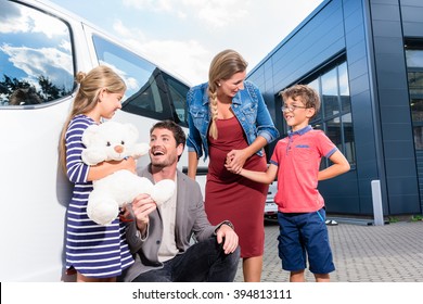 Family With Children Buying Auto At Car Dealer Standing In Front Of New Van