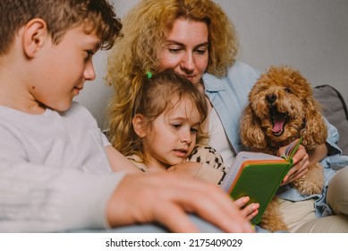 Family With Children And A Dog At Home On The Couch, Planning A Joint Business, Checking The Schedule In The Diary. Single Mother, Teenage Son, Little Daughter, Red Poodle. High Quality Photo