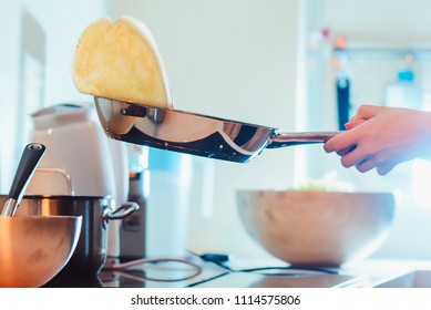 family, children, hapiness and people concept. Happy family with children preparing pancakes in the kitchen. electric cooker and frying pan with flying pancake - Powered by Shutterstock