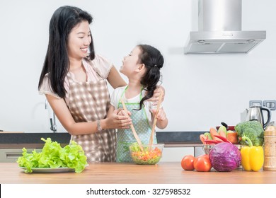 Family, Children And Happy People Concept - Asian Mother And Kid Daughter Cooking In The Kitchen At Home.