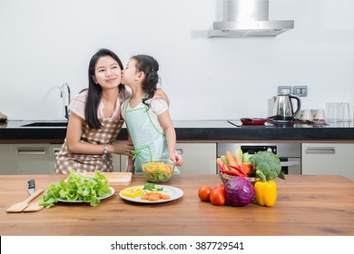 Family, Children And Happy People Concept - Asian Mother And Kid Daughter Cooking In The Kitchen At Home.
