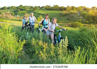 Family with children having a weekend excursion on their bikes on a summer day in beautiful landscape