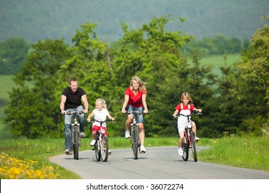 Family With Children Having A Weekend Excursion On Their Bikes On A Summer Day