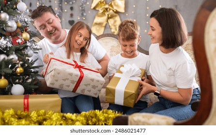 Family with children holding gifts in christmas - Powered by Shutterstock