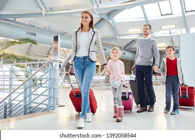 Family With Children And Luggage On Arrival After The Flight In The Airport Terminal