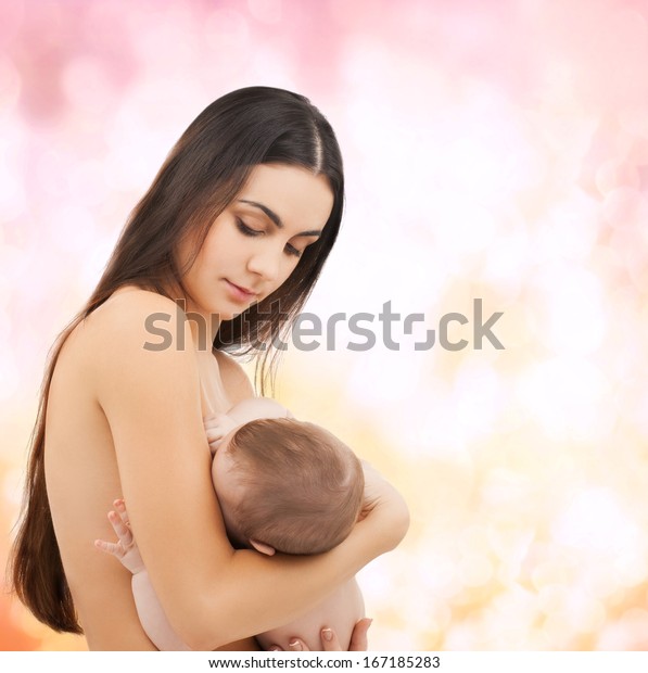 family, children, parenthood and
happiness concept - happy mother feeding her adorable
baby