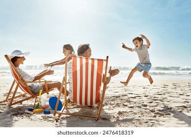 Family, children and playing at beach chair, vacation adventure and jump with bonding on summer journey. Parents, kids and excited for ocean freedom, energy and sunshine travel in Bali island - Powered by Shutterstock