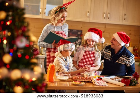 Family with children preparing cookies for Xmas in kitchen
