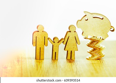 Family, Children, Saving Money, Investments  Concept. Wooden Family Figure And Piggy Bank On Golden Coin Stack On Wood Table.