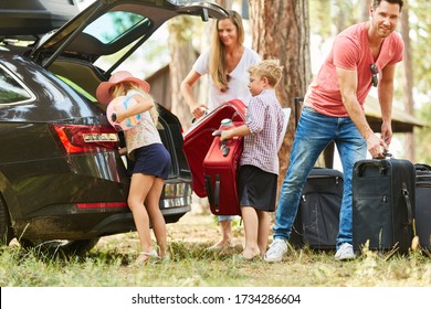 Family and children together at the suitcase packing at the car before the vacation trip
