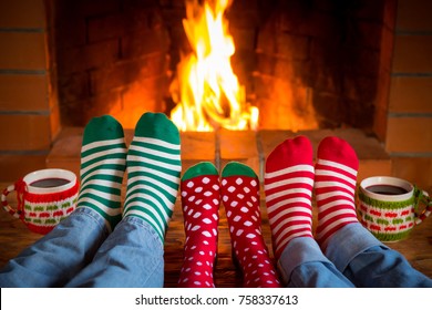 Family In Christmas Socks Near Fireplace. Mother; Father And Child Having Fun Together. People Relaxing At Home. Winter Holiday Xmas And New Year Concept