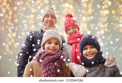 Family, Christmas, Winter, Season And People Concept - Happy Family Outdoors Over Holidays Lights Background And Snow