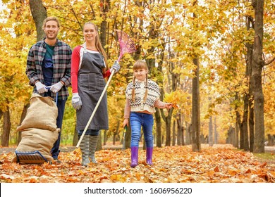 Family Cleaning Up Autumn Leaves Outdoors