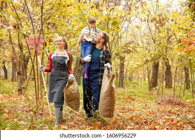 Family cleaning up autumn leaves outdoors - Shutterstock ID 1606956229