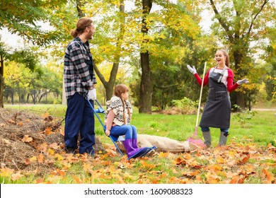 Family Cleaning Up Autumn Leaves Outdoors