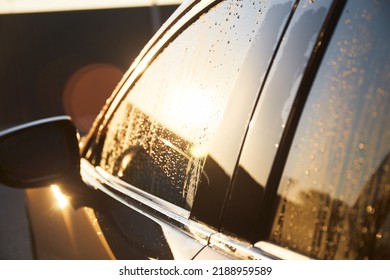 Family Cleaning Car In Self-service At Car Wash During Sunset. Car Covered In White Foam. Concept Of Easy And Fun Self-service