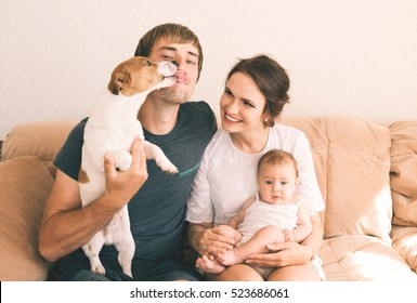 Family Close-up Portrait - Parents, Their Little Cute Baby Girl And Their Pet - Jack Russel Terrier Dog