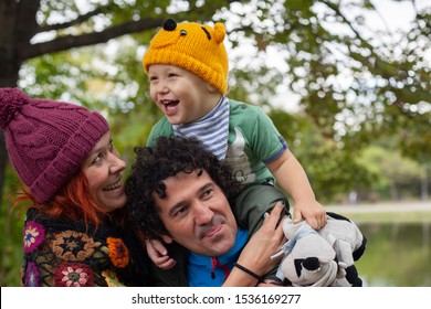 Family concept: happy mother, father and child outdoor; portrait of mix raced family outdoor. 