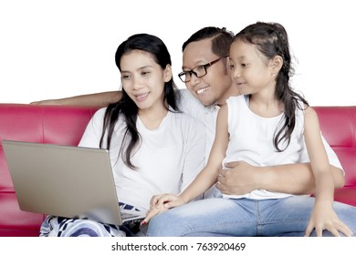 Family concept. Happy family sitting on the sofa while using a laptop computer together