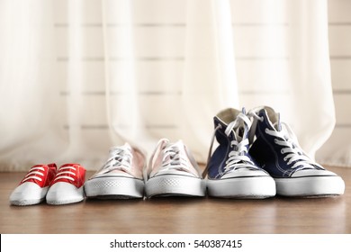 Family concept. Shoes for parents and child on floor in the room