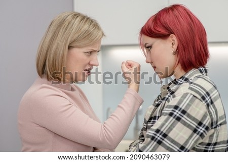 Family conflict. Angry mother threatens her teen daughter.