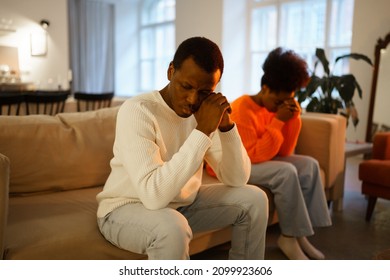 Family conflict. Young african american couple sit seperate on couch thinking of breakup or divorce. Black man and woman offended and upset after fight have problems in relationship. Selective focus