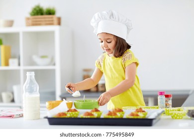 Family, Cooking, Baking And People Concept - Little Girl In Chefs Toque Making Batter For Muffins Or Cupcakes At Home Kitchen