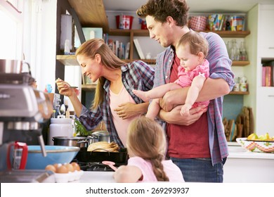 Family Cooking Meal In Kitchen Together