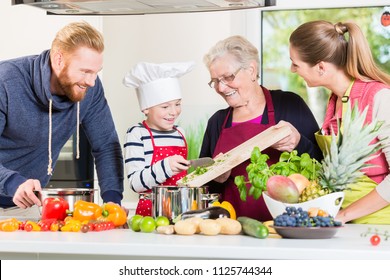 Family Cooking In Multigenerational Household With Son, Mother, Father And Grandfather