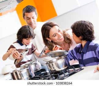 Family Cooking Together In The Kitchen And Looking Happy