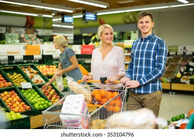 Family couple buying sweet fruits in local food shop