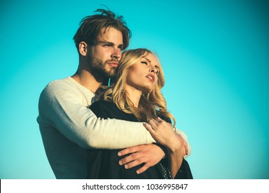 Family couple of man and sexy girl, trust. Muscular man and woman with long blond hair, love. Relations of happy family, future. Couple in love on blue sky background. Love and romance.