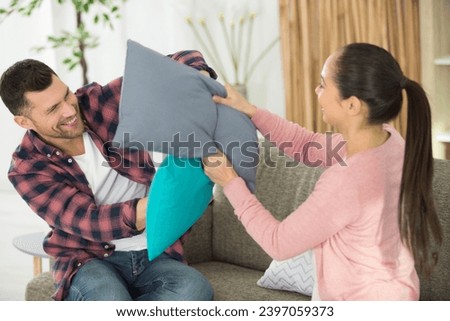 family couple pillow fighting and playing fool together